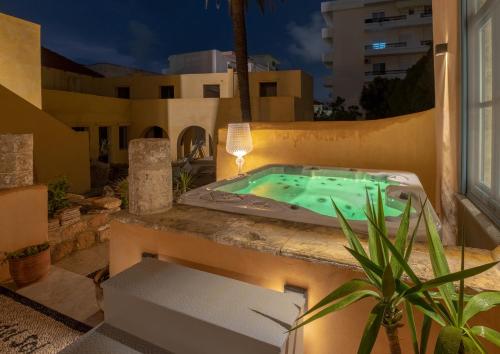 罗德镇Casa del Sol Suites的晚上在房子阳台上的按摩浴缸