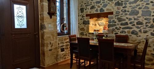 AnópolisFILEMA HOME (stone house)的一间设有桌子和石墙的用餐室