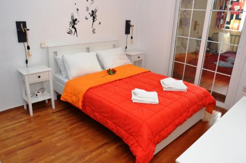 雅典Helen house的一间卧室配有红色的床和2条毛巾