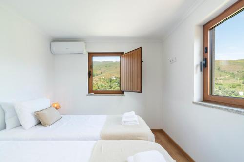 VideNEW - Casa das Domingas的白色的客房设有两张床和窗户。