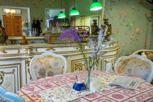 姆茨赫塔Tatin - Hotel & Café in Mtskheta的用餐室,配有花瓶桌子