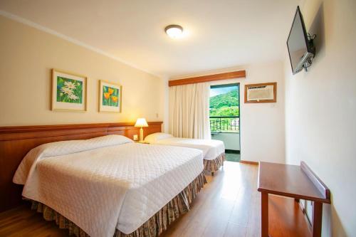 阿瓜斯迪林多亚Hotel Monte Real的酒店客房设有两张床和电视。