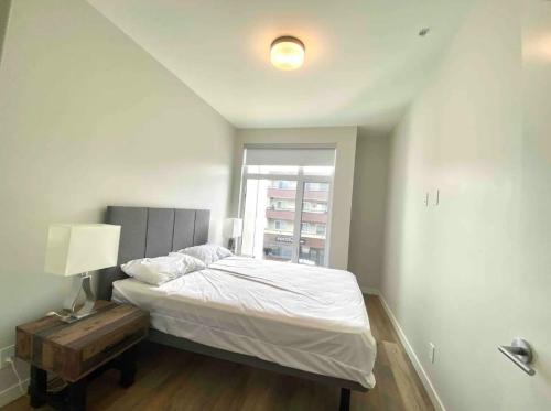悉尼Brand New 3-Bedroom Condo in the Heart of Sidney的一间卧室配有床、灯和窗户