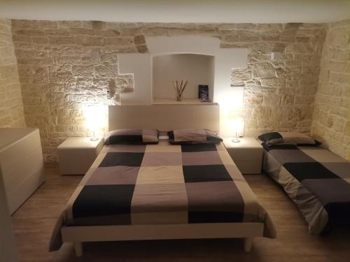 焦维纳佐B&b il castello的一间带两张床铺的卧室,位于带石墙的房间内