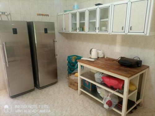 伊尔比德Decapolis的厨房配有不锈钢冰箱和桌子