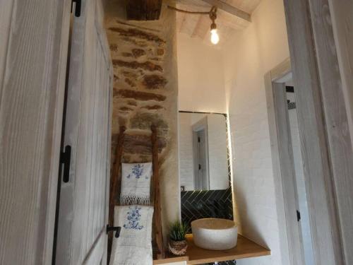 Cortes de ArenosoLa Esencia Casa Rural的浴室设有镜子和带毛巾的架子