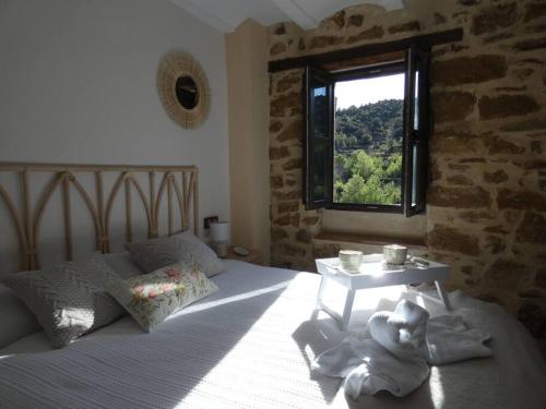 Cortes de ArenosoLa Esencia Casa Rural的一间卧室配有一张带窗户和桌子的床