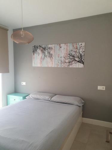 阿尔么丽亚Casa Azul de la Almedina de Almería的卧室配有一张床,墙上挂有绘画作品