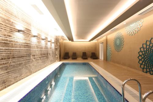 伊斯坦布尔塔克西姆优质套房公寓的一座位于酒店带瓷砖墙的游泳池