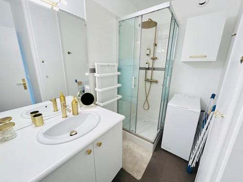 拉格朗德默特Studio chic et cosy vue mer的白色的浴室设有水槽和淋浴。