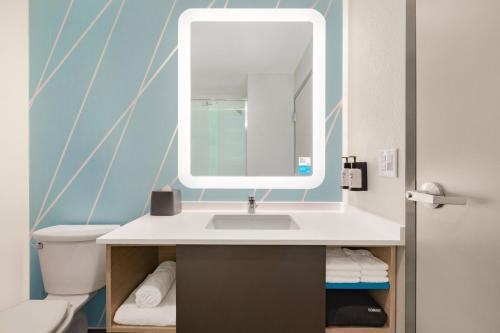 塔尔萨avid hotels - Tulsa Hills的一间带水槽和镜子的浴室