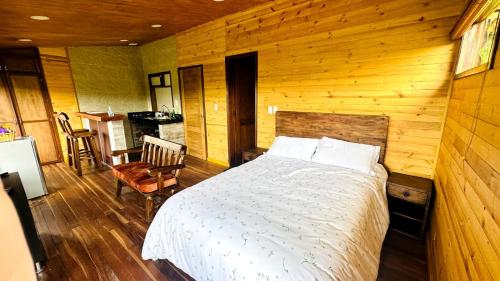 拉卡莱拉Eco Cabañas del Encanto, La Calera的木制客房内的一间卧室,配有一张床