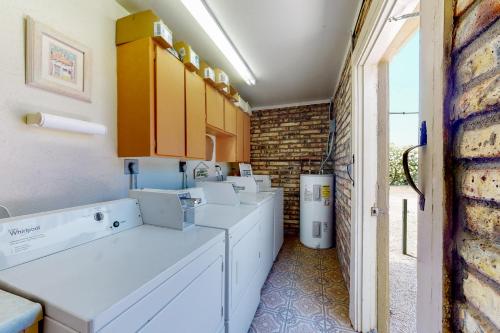 卡立佛里Tranquil Trail #8的一间洗衣房,配有白色家电和砖墙