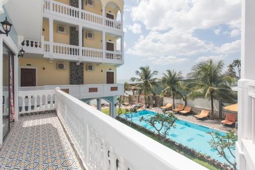 美奈格雷斯精品度假村酒店的一个带游泳池和大楼的阳台