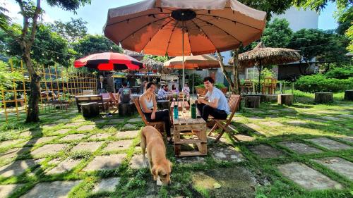 宁平Ninh Binh Bamboo Farmstay的一群人坐在桌子上,带着狗