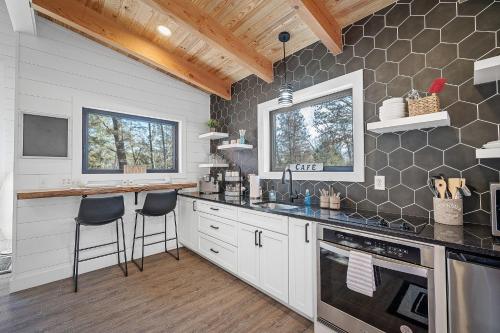High HillWhispering Pines - Lakeside的厨房配有白色橱柜和黑色台面