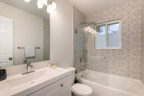 丹佛Mile Hi: Amenities Galore的浴室配有盥洗盆、卫生间和浴缸。