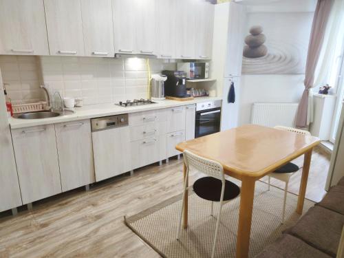 基希讷乌Guest House Гостевой Дом的厨房配有白色橱柜和木桌