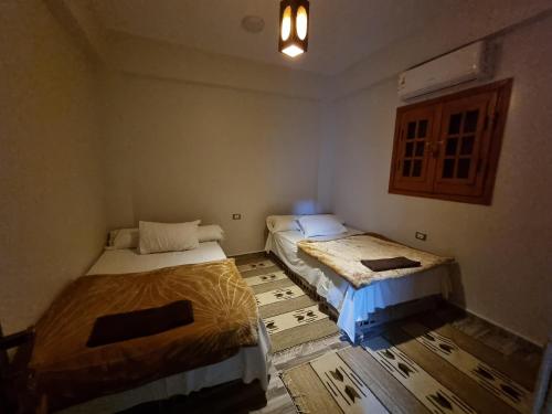 锡瓦SEMIRAmis Siwa的一间铺有木地板的客房,配有两张床