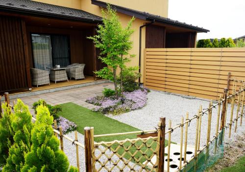 富士河口湖Hananoyado Yumefuji的一座带围栏的房屋前的花园