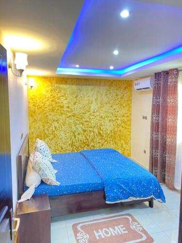 杜阿拉N-E Meublé 1的一间卧室配有一张黄色墙壁的床