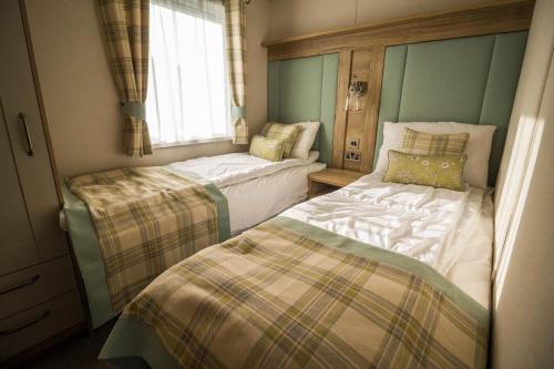 Hopton on SeaLuxury Lodge With Stunning Full Sea Views In Suffolk Ref 20234bs的小房间设有两张床和窗户
