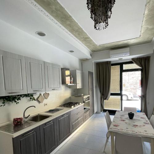 雷卡纳蒂港La Rondine rental apartment的厨房配有白色橱柜、桌子和吊灯。