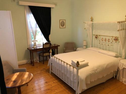 波特兰罗蕾莱住宿加早餐旅馆的一间卧室配有一张床、一张桌子和一个窗户。