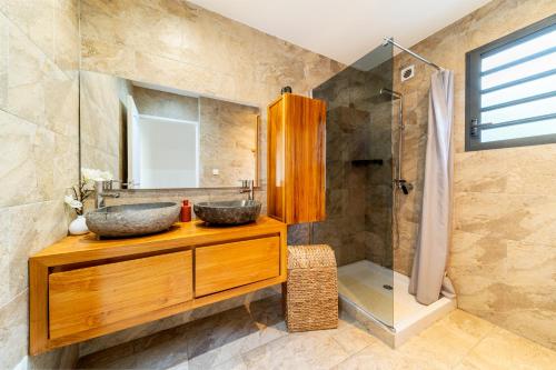 珀蒂蒂勒VILLA L HORIZON 4 appartements avec piscine的一间带两个盥洗盆和淋浴的浴室
