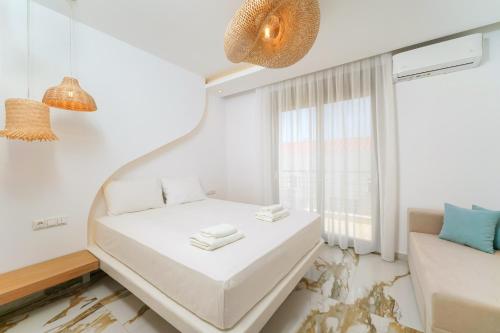 波托什Athina Palace Luxurious Appartments的一间白色的小房间,配有床和窗户