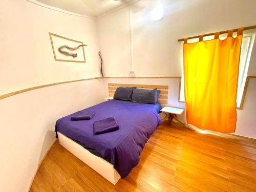 图鲁斯杜Thulusdhoo Garden Villa的一间卧室配有一张带紫色床单的床和窗户。