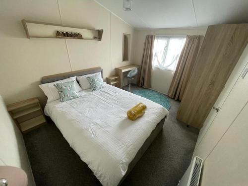 滨海克拉克顿Modern 6 Berth Caravan With Wifi At St Osyth Beach In Essex Ref 28051fv的一间卧室,床上有黄色的物体