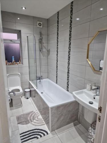 沃特福德Central Watford Modern Apartment - Travellers & Contractors Welcomed的带浴缸、卫生间和盥洗盆的浴室