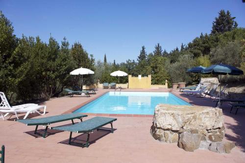 基安蒂格雷夫Corte Di Valle的一个带两张野餐桌和遮阳伞的游泳池