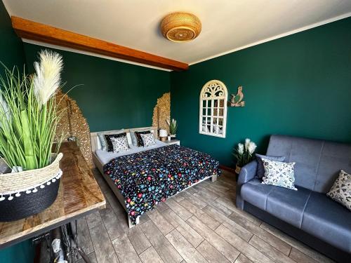 切米诺Kaszubskie Zacisze的一间卧室设有绿色的墙壁、一张床和一张沙发