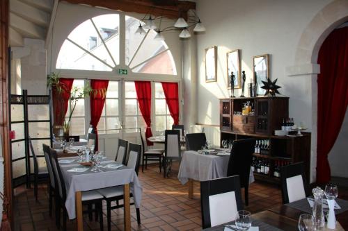 Azay-le-Ferron特里布里恩酒店的餐厅设有桌椅和大窗户。