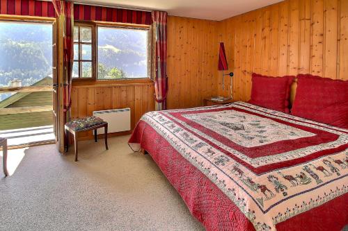 尚佩里Triplex Overlooking The Village - Terrace & Bbq的一间卧室配有一张带红色枕头的床和一扇窗户
