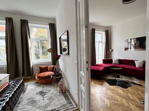 维也纳NEW Exclusive 100m2, Top location!的客厅配有红色的沙发和桌子