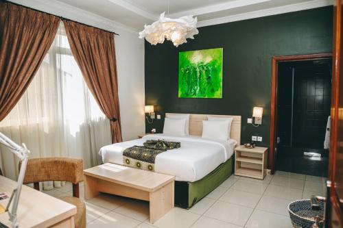 基加利Amata n'Ubuki Boutique Hotel的卧室配有白色的床和绿色的墙壁