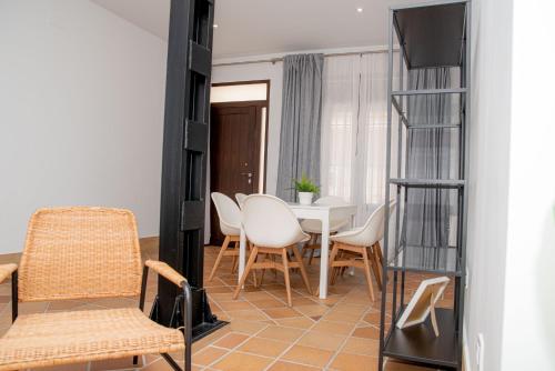 阿尔哈拉克Apartamentos Casa Tuli A, ALJARAQUE的客厅配有桌椅和电视。