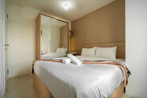 雅加达Premium 2BR @ Bassura City East Jakarta的一间卧室配有一张大床和大镜子