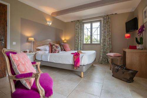 圣保罗-德旺斯Hotel Les Messugues的一间卧室设有一张大床和一个窗户。