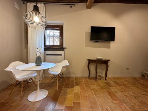 克利通诺河畔坎佩洛Borgo Lizori Country House的一间带桌椅和电视的用餐室
