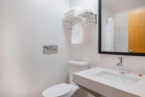 德卢斯德卢斯速8酒店的一间带卫生间、水槽和镜子的浴室