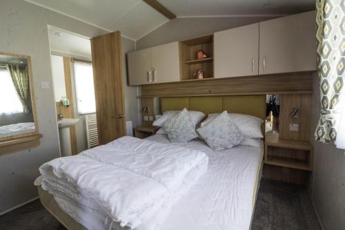 斯凯格内斯Beautiful 6 Berth Caravan At Southview Holiday Park In Skegness Ref 33031s的卧室配有一张带白色床单和枕头的大床。
