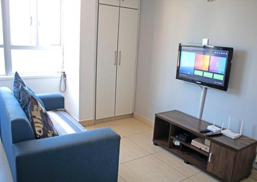 德班Unit 104 @Tenbury的客厅配有蓝色的沙发和电视