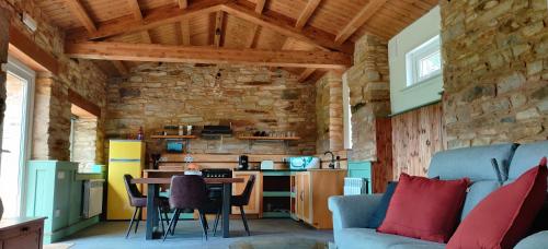 卢戈Galician Rural Accommodation - La Casita的厨房以及带桌子和沙发的客厅。