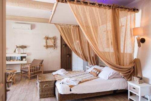 圣吉尔Abri Cosy - Suite Romantique的一间卧室配有一张床,床上挂着窗帘
