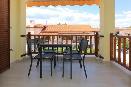 尼基季Agapitos Apartments的阳台的门廊配有椅子和桌子