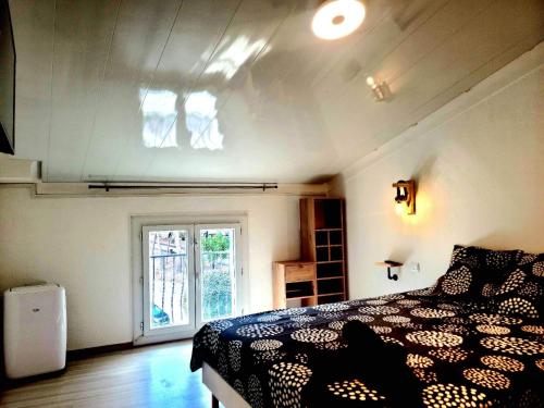 科利尤尔Charmante maison de village Collioure的卧室设有黑白床和窗户。